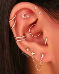 an ear with three different types of piercings