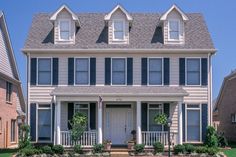 a two story house with white trim and black shutters