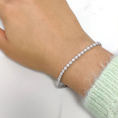 a woman's hand wearing a diamond bracelet