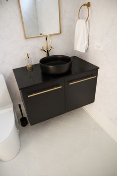 a bathroom with a sink, mirror and toilet paper roll on the floor next to it