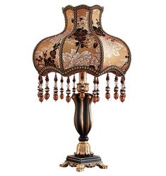 a table lamp with an intricately decorated shade on it's base and beaded trimmings