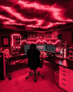 a man sitting at a desk in front of two computer monitors with red lights on them