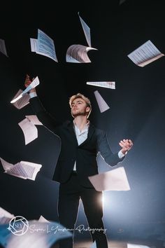 a man in a suit is throwing papers into the air