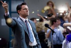 a man in a suit and tie is giving a speech to a group of people