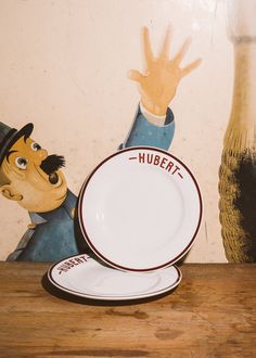 a plate with a cartoon character on it next to a wallpapered background that says hubeitt