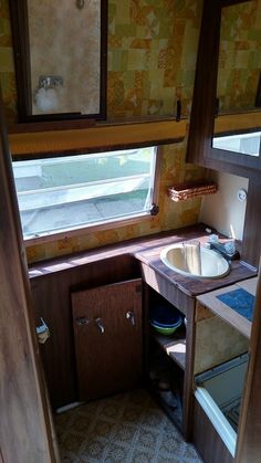 the inside of a small bathroom with a sink and mirror in it's corner