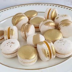 a white plate topped with macaroons covered in gold