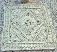 a crocheted doily on a lace tablecloth