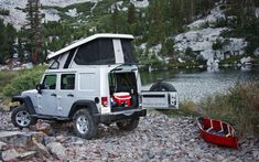 a gray jeep parked on top of a rocky field