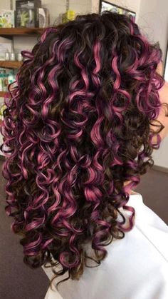 the back of a woman's head with purple and black curly hair in it