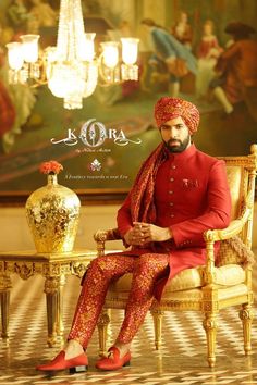 a man sitting on top of a chair wearing a red suit and turban