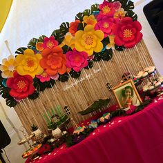 a table topped with lots of colorful paper flowers