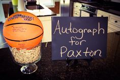 a basketball sitting on top of a counter next to a sign that says autograph for paxton