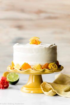 a white cake with oranges and lime on top