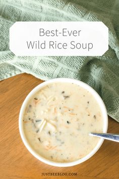 the best ever wild rice soup in a white bowl on a wooden table with a spoon