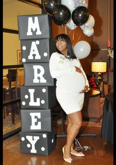 a woman in a white dress standing next to a sign that says marely on it