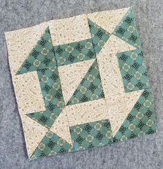 the block is made up of green and white fabric, with an arrow on it