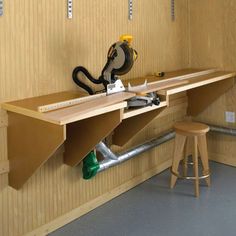 a workbench with tools on it in a wood paneled area next to stools