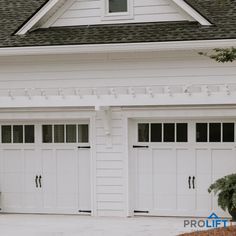 Two white carriage house garage doors with windows, black handles and hinges by ProLift Garage Doors Stylish Garage, Tall Garage, Faux Wood Garage Door