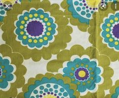 a green and blue flowered fabric with a measuring tape on it's side