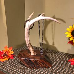 a wooden stand with an animal's head on it and flowers in the background