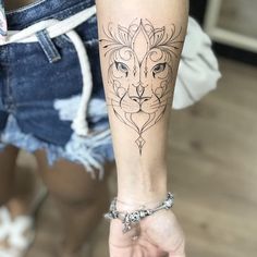 a woman's arm with a tattoo on it and a lion head in the middle