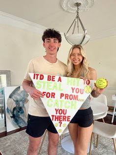 a man and woman holding up a sign