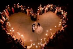 a bride and groom are surrounded by sparklers in the shape of a heart