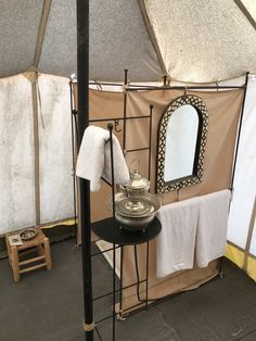 the inside of a yurt with white towels and mirrors