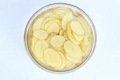 sliced apples in a glass bowl on a white background