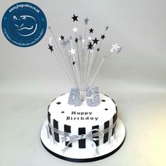 a white and black birthday cake with silver stars on the top that says 365 happy birthday