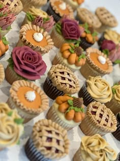 many cupcakes are decorated with flowers and leaves