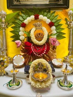 there is a small statue with flowers on it and other decorations around the shrine area