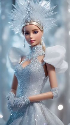 a barbie doll wearing a silver dress and tiara in front of snow - covered trees