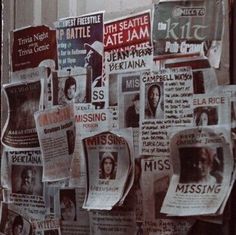 newspapers are hanging on the wall in front of a building with posters attached to it