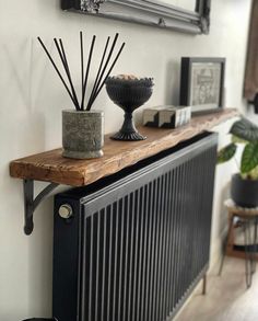 a radiator with some candles on top of it and pictures above the radiator