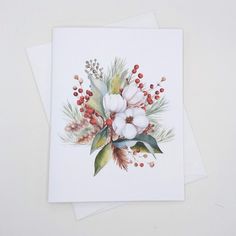 two cards with flowers on them sitting next to each other, one is white and the other has red berries