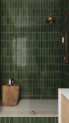 a green tiled bathroom with a wooden standup shower