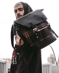 a man carrying a black and red plaid backpack