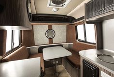 the interior of a motor home with kitchen and dining area