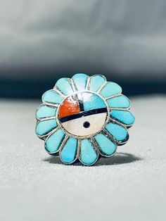 "MAKE US AN OFFER BY CLICKING THE \"MESSAGE SELLER\" Button- Up for sale is this marvelous vintage Zuni silver ring having an inlay sunface of turquoise, coral, jet and mother of pearl surrounded by inlay turquoise teardrops with a scalloped silver border and a handcarved solid silver band! Absolutely Captivating! The ring face measures around 7/8\" x 7/8\". The ring size is around 8. Sterling silver. Sturdy 5 grams. Cir mid century. Make Us an Offer- Due to the high demand of our items, many pi Collectible Blue Turquoise Inlay Ring, Collectible Round Turquoise Ring, Antique Handmade Turquoise Blue Ring, Antique Handmade Blue Turquoise Ring, Handmade Antique Blue Turquoise Ring, Handmade Antique Turquoise Ring, Handmade Blue Turquoise Ring For Collectors, Vintage Blue Turquoise Cabochon Ring, Vintage Blue Cabochon Turquoise Ring