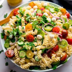 a white bowl filled with pasta salad on top of a table