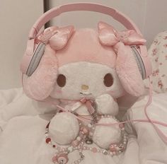 a white stuffed animal with headphones on top of it's ears and necklaces