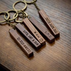 three wooden key chains with engraved names on them