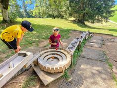 two people are working on an obstacle in the park, one is trying to build a bridge