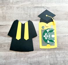 a paper cutout of a starbucks cap and gown next to a card with the starbucks logo on it