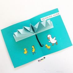 an origami umbrella with ducks on it and the words sending hugs written below