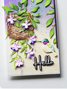 a handmade card with flowers and a bird on the tree branch that says hello