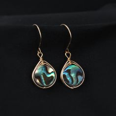 Why abalone? Because its one of the most beautiful shells in the ocean. Wire wrapped, these abalone shells give a pop of color you are guaranteed to love! Please note, all abalone shells vary. The colors include dark and light blues, greens and hints of purple, reds, and browns. Patterns vary from simple to complex swirls, stripes, and anything between! Get these earrings in the perfect light and the colors will shine and glow beautifully! *Also available in sterling silver, oval shape, and smal Handmade Teardrop Shell Gift, Gift Iridescent Earrings With Wire Wrapped, Gift Iridescent Wire Wrapped Earrings, Abalone Shell Jewelry For Pierced Ears As Gift, Abalone Shell Earrings For Pierced Ears As A Gift, Wire Wrapped Abalone Shell Jewelry For Gifts, Gift Abalone Shell Earrings For Pierced Ears, Teardrop Abalone Shell Jewelry With Matching Earrings, Handmade Teardrop Abalone Shell Jewelry