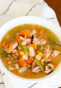 a white bowl filled with chicken and vegetable soup